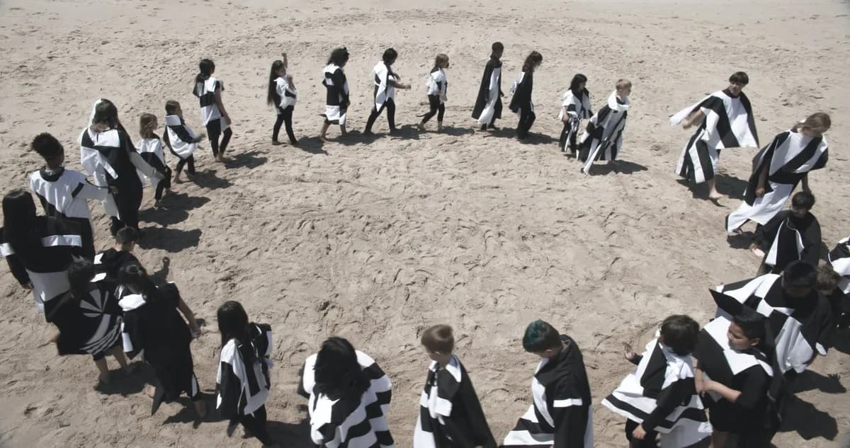 A group of performers forming a wide circle outdoors